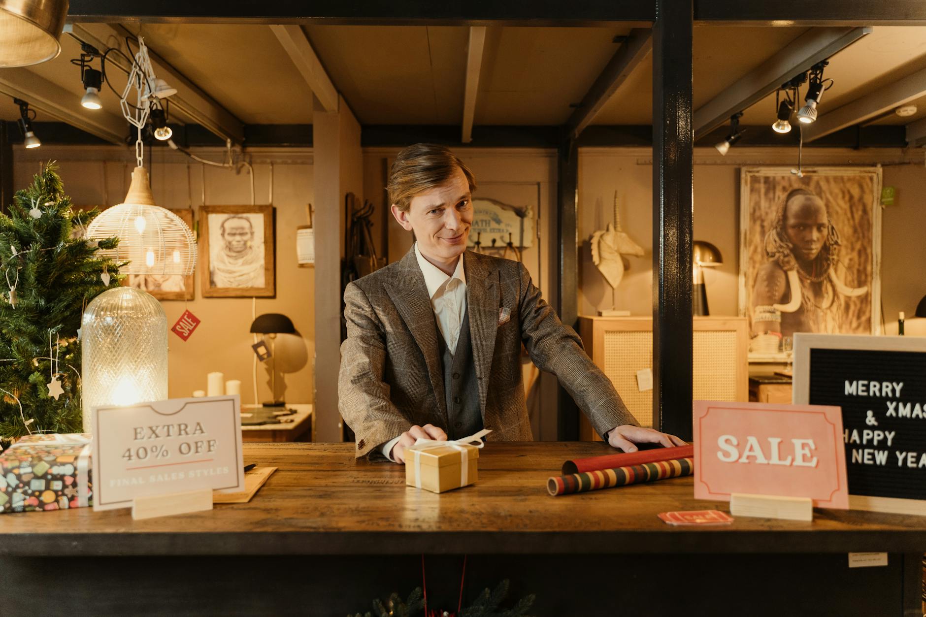 man in gray suit standing near a wooden counter